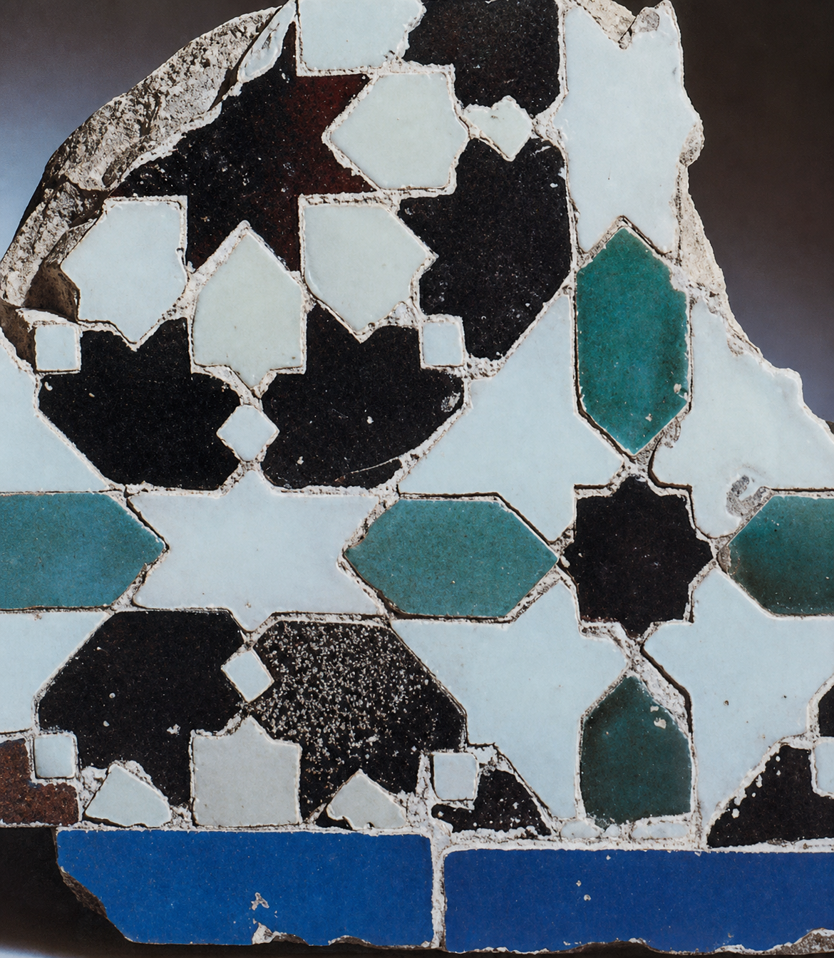 Previously shown fragment of the Alhambra tilework: its local symmetries are evident building, but in the binding together and local symmetry of smaller centers within the whole.